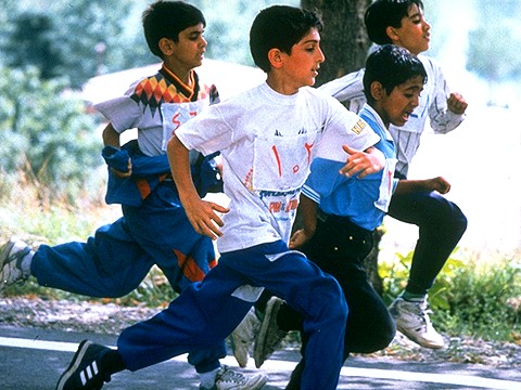 A shot of three young Iranian boys running in a race.